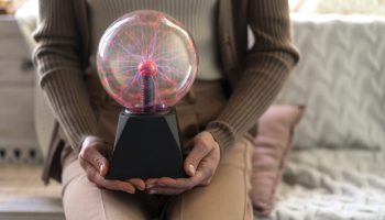 front-view-woman-interacting-with-plasma-ball